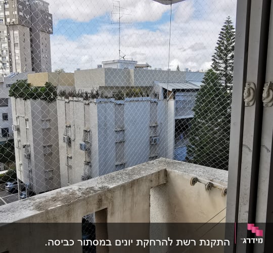 רשת נגד יונים מותקנת על מרפסת עם חבל כביסה